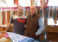 Massimo e il figlio Govinda dietro al loro banco di stoffe al mercato del Villaggio Olimpico del Venerdì